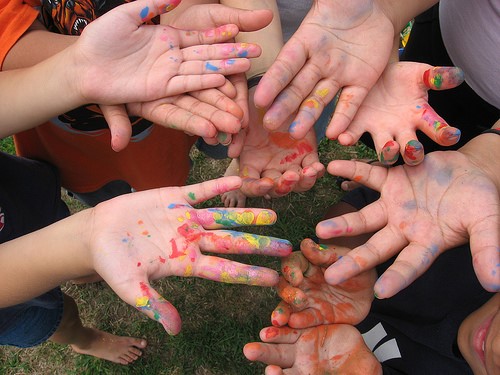 Image of children's hands covered in different coloured paint
